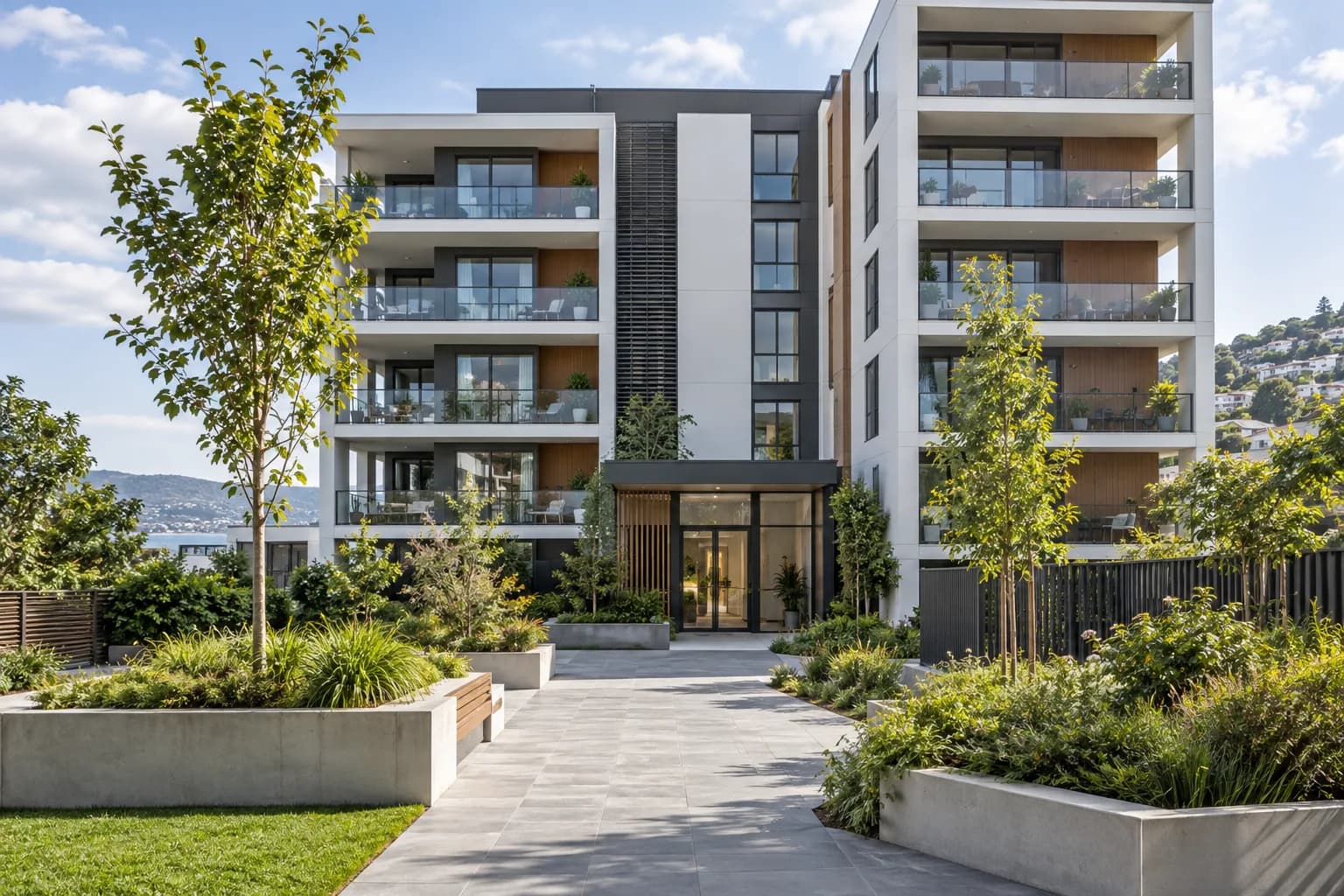 Modern apartment building with balconies and a shared landscaped entrance